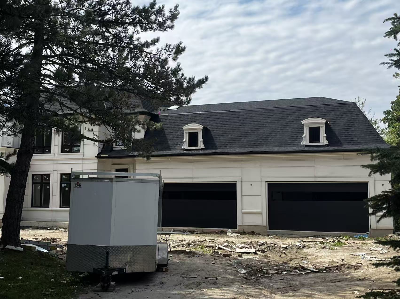 Current garage side of the property with construction debris and unfinished grade
